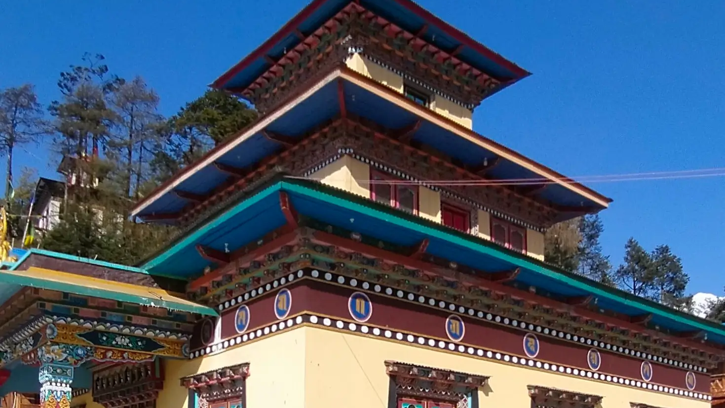 Buddhist monastery on the Manaslu Circuit Trek with prayer flags and a Himalayan mountain backdrop in Nepal.