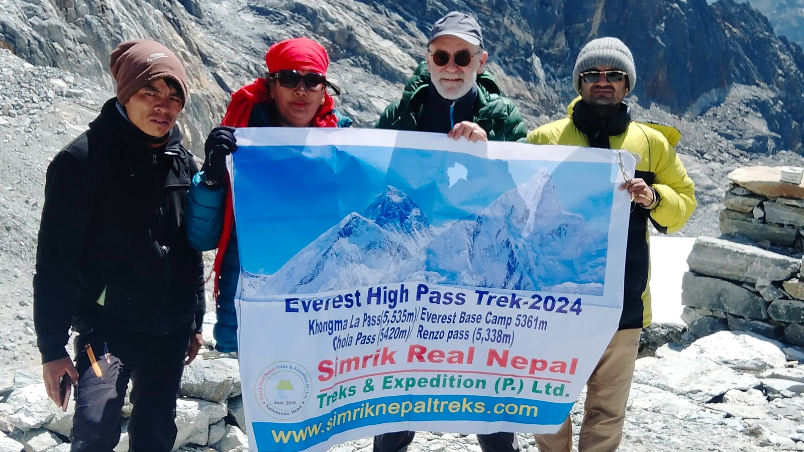 Trekkers crossing the icy Cho La Pass trail (5,420 m) on the Everest Three Passes Trek, surrounded by snow-capped Himalayan peaks and glaciers.