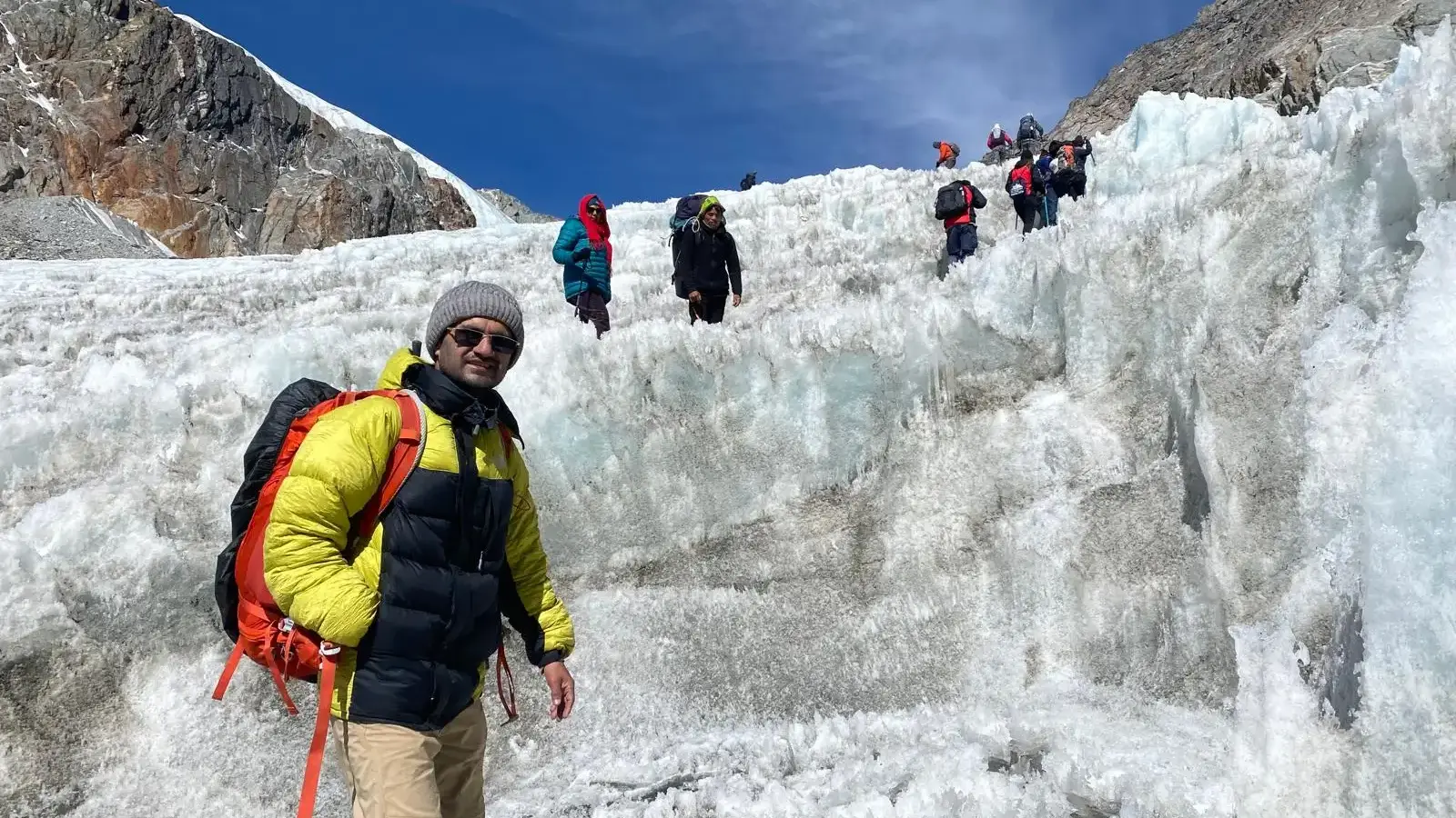Trekkers crossing the icy Cho La Pass trail (5,420 m) on the Everest Three Passes Trek, surrounded by snow-capped Himalayan peaks and glaciers.