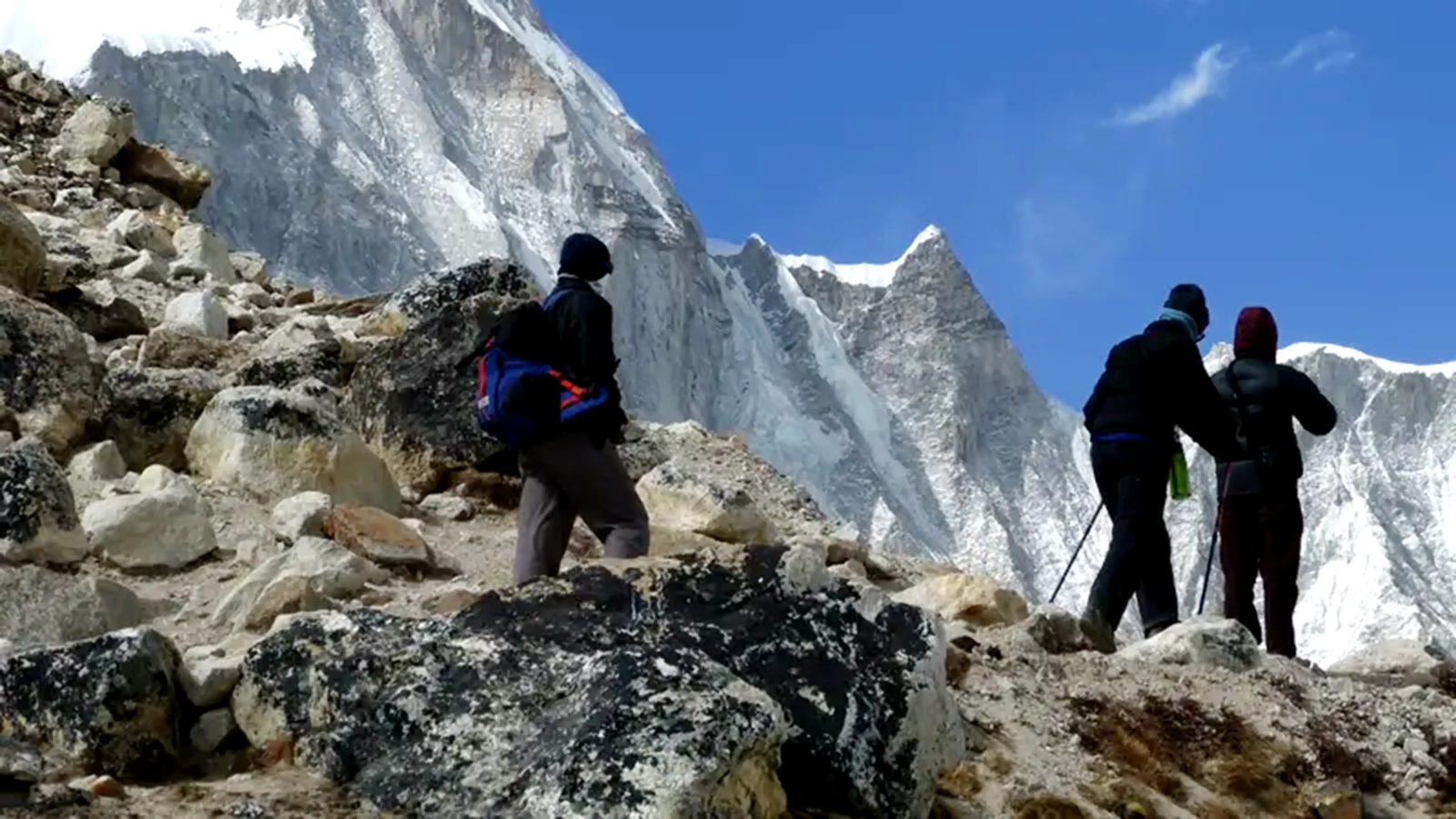 Everest High Passes Trek: Trekkers walking beneath dramatic Himalayan peaks near Everest Base Camp