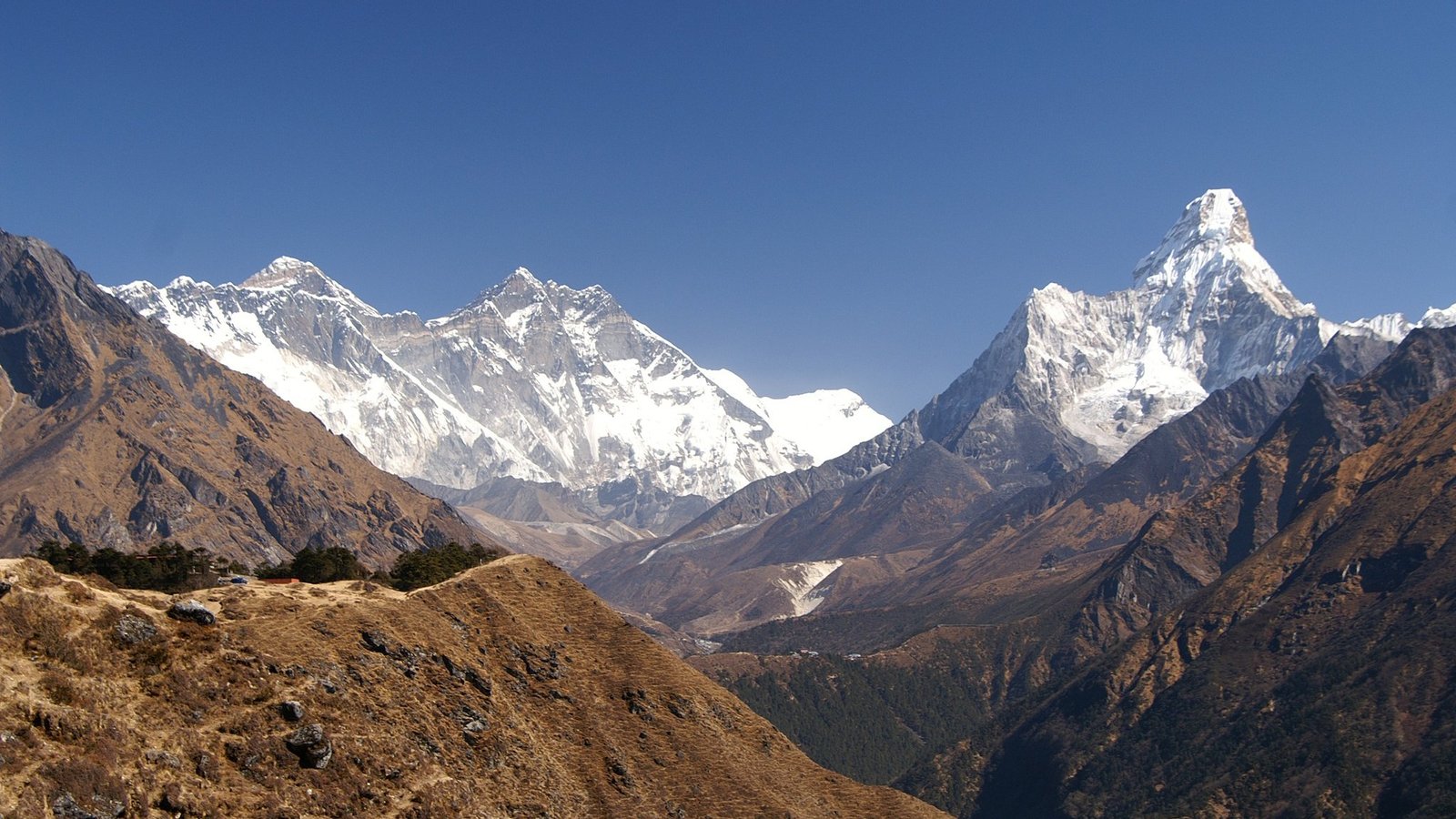 Hikers on the trail to Everest View Hotel above Namche Bazaar, clear autumn sky