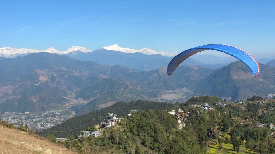 Paragliding in Pokhara with panoramic views of the Annapurna Range and lush valleys below