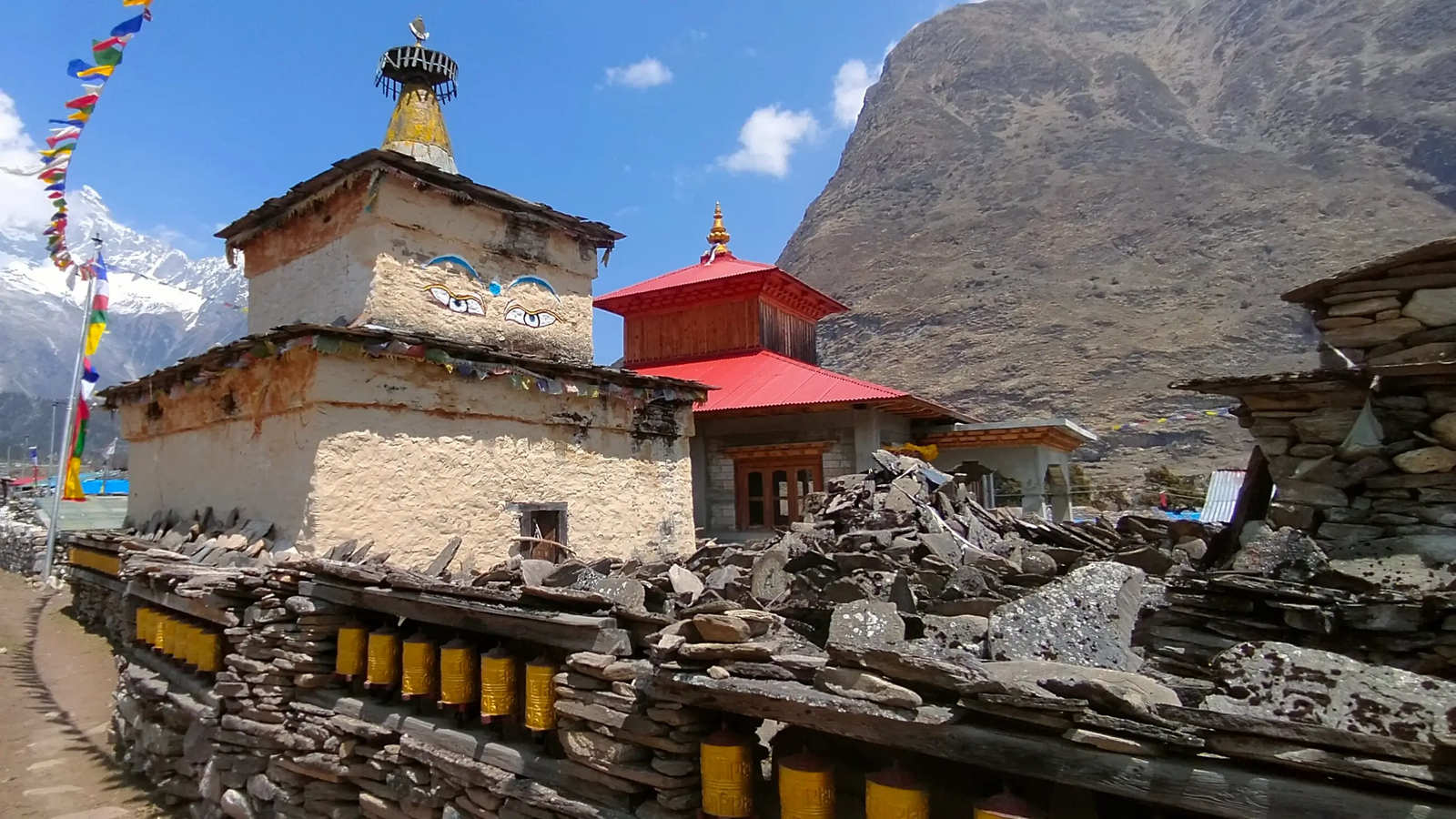 Samagaon village monastery on the Manaslu Circuit Trek with traditional Tibetan architecture, prayer flags, and Himalayan mountain backdrop in Nepal.