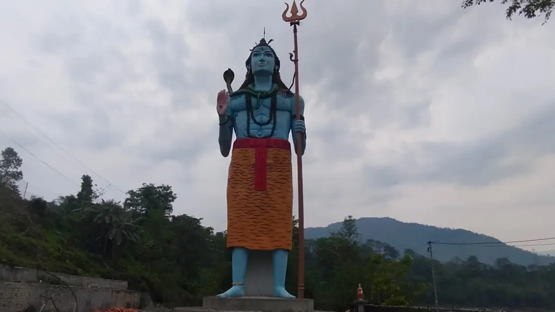 Statue of Lord Shiva Hindu god in Nepal with trident scenic hills background spiritual pilgrimage site