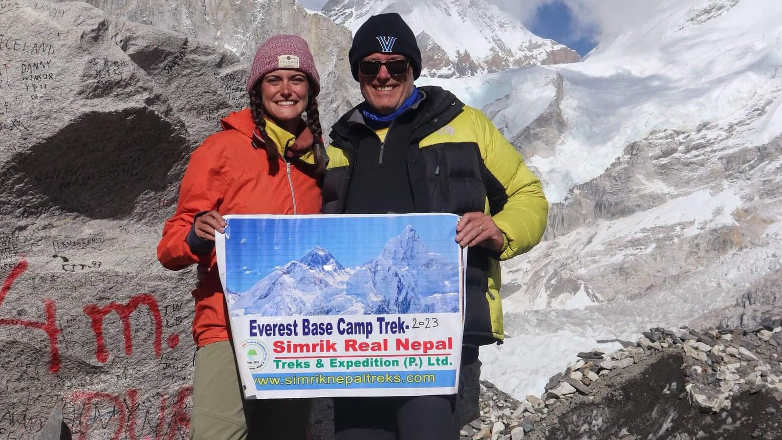 Trekkers holding Simrik Real Nepal Treks banner at Everest Base Camp
